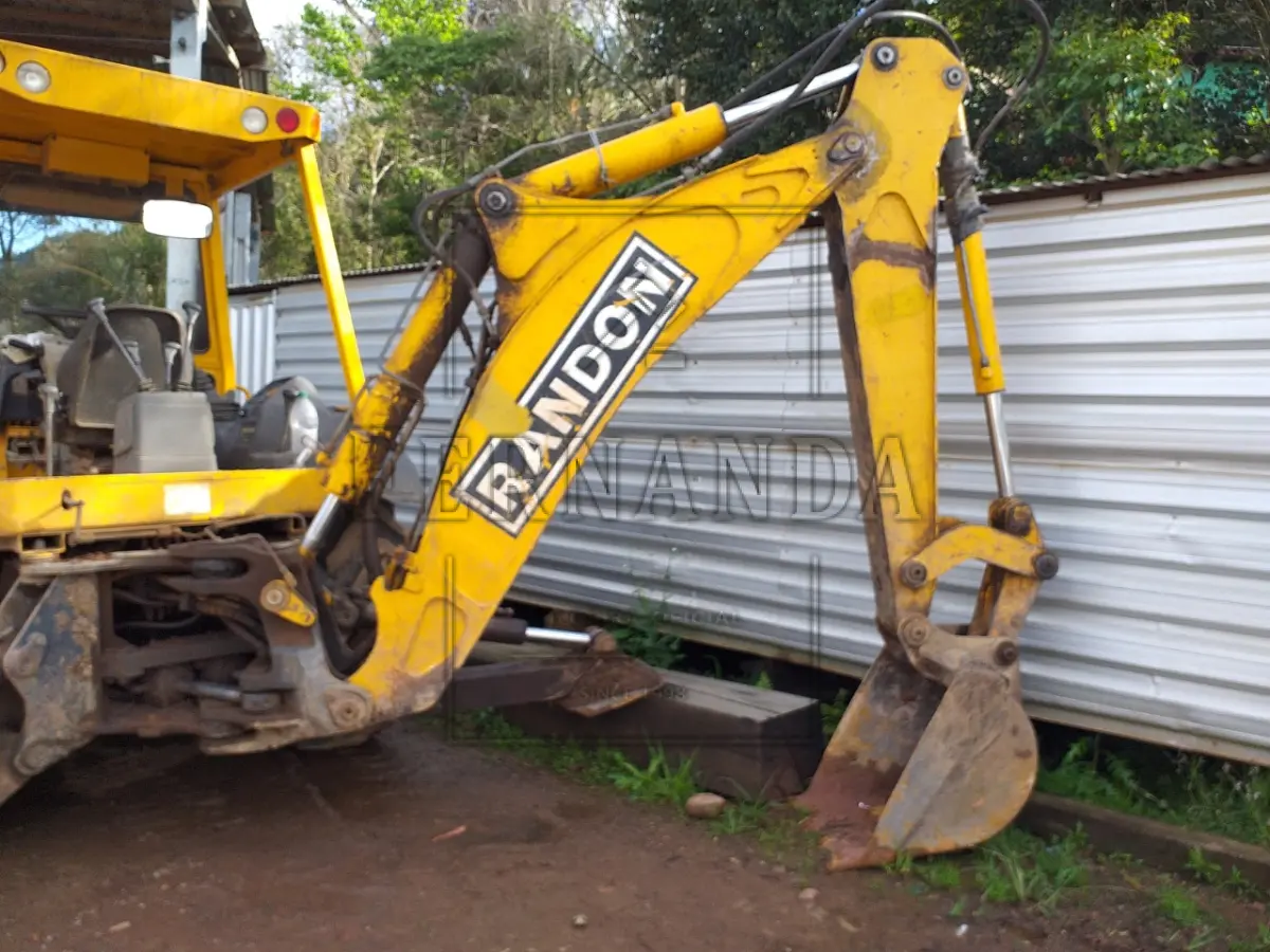 LOTE 004 - Um trator de rodas (retroescavadeira) marca Randon, modelo RK406B, ano de fabricação e modelo 2010, cor amarela, combustível diesel, em regular estado de conservação, funcionando.